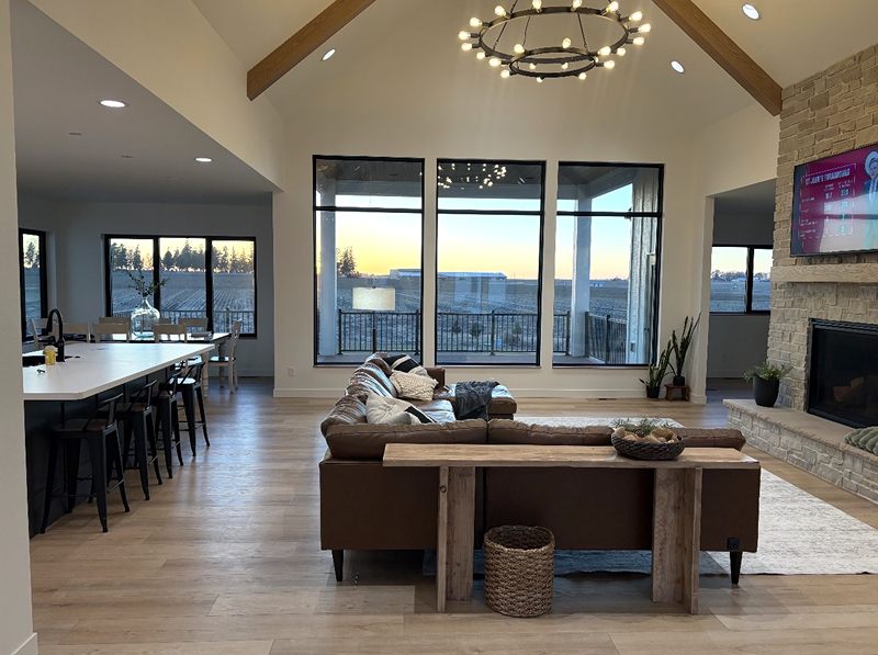 Vaulted great room with exposed beams and a stone fireplace