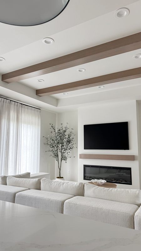 Living room with wood ceiling beams and a linear fireplace