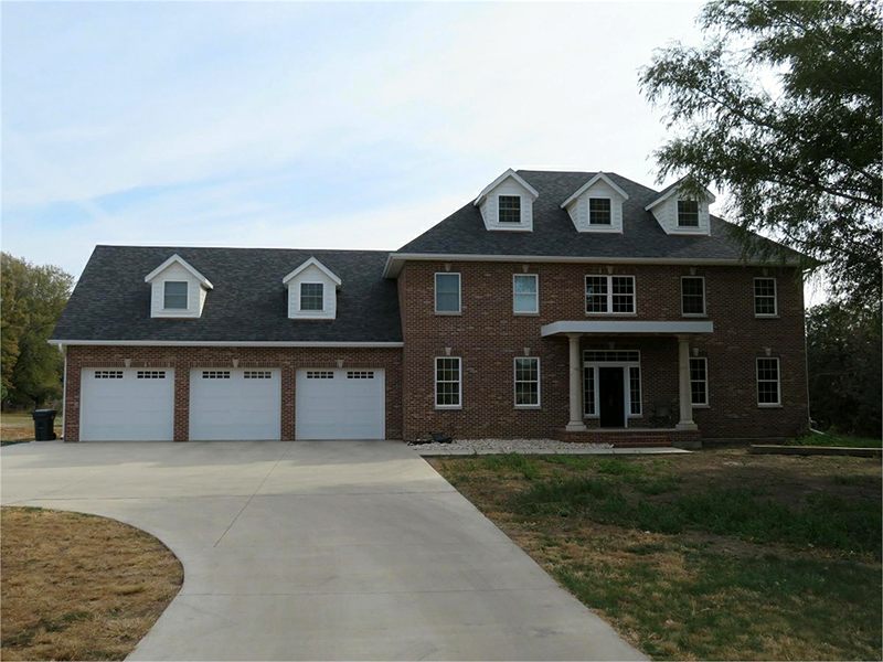 Two-story brick home with dormers and a three-stall garage