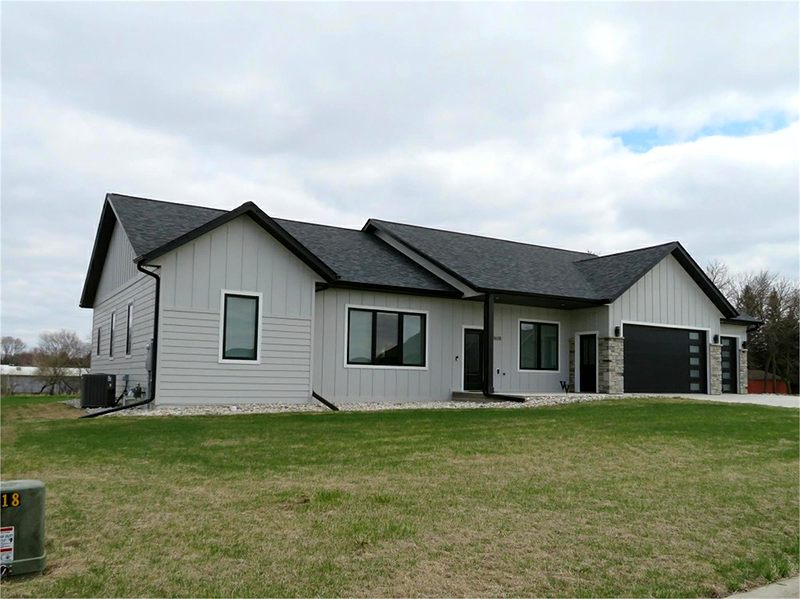White ranch home with black windows and a black garage door