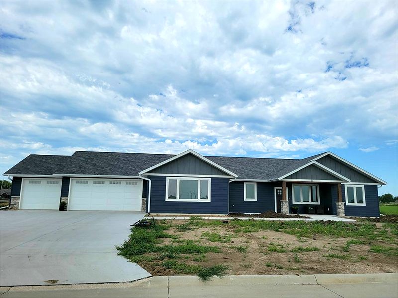 Navy blue ranch home with a three-stall garage