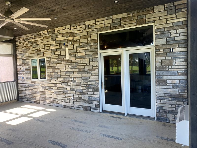 Stone veneer wall on a covered patio with French doors